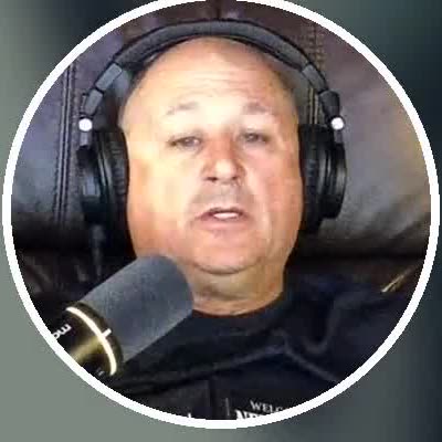 Chief Chuck in his studio wearing a headset, speaking into a microphone